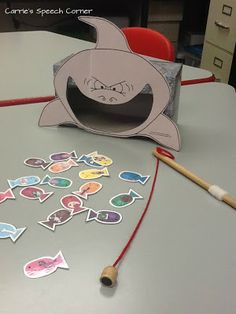 a shark shaped box sitting on top of a table next to a pencil and paper