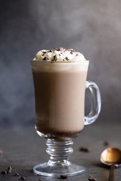 a glass cup filled with hot chocolate and whipped cream