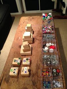 a wooden table topped with lots of different types of buttons and magnets on top of it