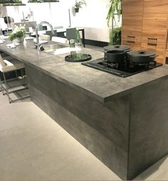 a kitchen island with pots and pans on it in the middle of a room