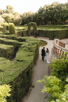 a bride and groom are walking through the mazed gardens at this wedding venue in italy