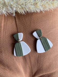 two white and green earrings with bows on them