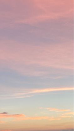 two people standing on the beach with surfboards in their hands, watching the sunset