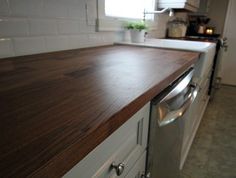 a wooden counter top in a white kitchen