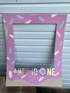 a pink frame with sprinkles on it that says and is one