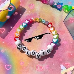 a bracelet with the word love spelled on it in front of a rainbow - hued background