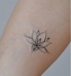 a small black and white flower tattoo on the arm