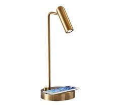 a gold desk lamp with a cell phone on it