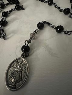 Handmade black beaded rosary.  20 in long with religious charm. Bead and chain work.  In good condition. Black Beaded Cross-shaped Rosary, Black Beaded Cross Rosary, Vintage Black Rosary As A Gift, Vintage Black Rosary As Gift, Vintage Black Rosary Gift, Black Crucifix Rosary Bracelet As Gift, Handmade Black Cross Rosary Bracelet, Black Spiritual Rosary Bracelet With Cross, Black Rosary Bracelet With 8mm Beads For Jewelry Making