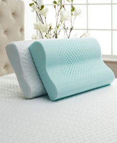 a memory pillow sitting on top of a bed in front of a window with white flowers