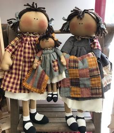 two dolls sitting on top of a wooden bench