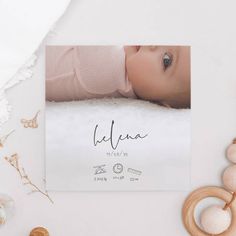 a baby's birth announcement is shown on top of a white table with toys