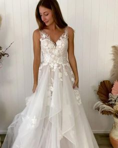 a woman wearing a white wedding dress with flowers on it