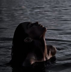 a woman floating in the water with her eyes closed