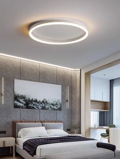 a large bed sitting under a round light in a bedroom next to a painting on the wall