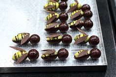 chocolate candies are arranged in the shape of bee's on a baking sheet