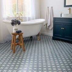 a white bath tub sitting next to a wooden stool