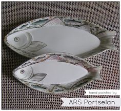 two fish shaped dishes sitting on top of a table