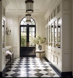 a foyer with black and white checkered flooring, chandelier and door