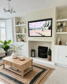 a living room with a large flat screen tv on the wall above a fire place