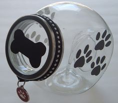 a glass jar with a dog's paw print on the front and bottom, hanging from a chain