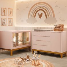 a baby's room with two cribs, a dresser and pictures on the wall