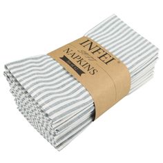 four white and gray striped napkins stacked on top of each other with brown paper