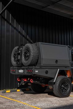 an off - road vehicle parked in front of a building with two tires on the back