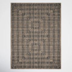 an area rug with black and tan squares on it, in the middle of a white wall