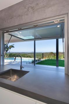 a kitchen with a sink and large window overlooking the pool area in front of it