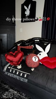 a black bed with red and white pillows on it