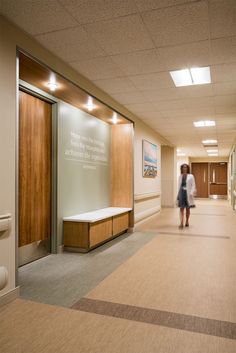 a woman walking down a hallway in an office building