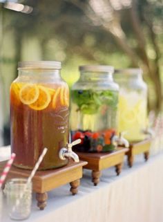 three mason jars filled with liquid sitting on top of a table