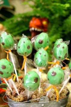 there are many green cake pops in the bucket