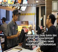 two men standing at a cash register in a fast food restaurant talking to each other