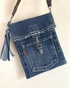 a purse made out of an old pair of jeans with a keychain hanging from it