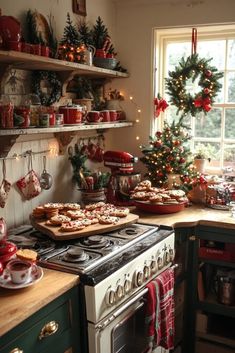 a kitchen decorated for christmas with red and green decorations on the windowsills, an oven, and shelves filled with dishes