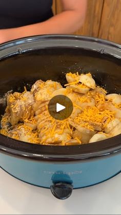 a slow cooker filled with food sitting on top of a table