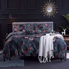 a bedroom with black walls and floral bedding