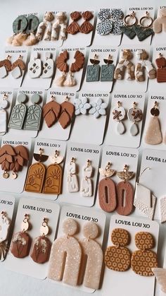 many different types of earrings are displayed on a white table with the words love you so much written below them