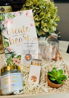 an open box containing candles, cards and succulents with a note inside