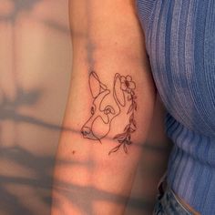 a woman's arm with a tattoo on it that has a dog and flowers