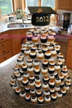 cupcakes are stacked on top of each other in the shape of a graduation cap