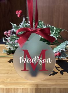 a christmas ornament with the letter m hanging from it's side on a table