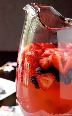 a pitcher filled with fruit sitting on top of a table