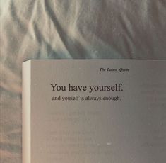 an open book sitting on top of a bed next to a white sheet with the words you have yourself