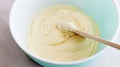 a blue bowl filled with white batter and a wooden spoon