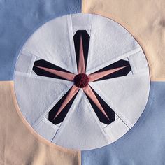 a piece of cloth with a pink and black cross in the center on top of it