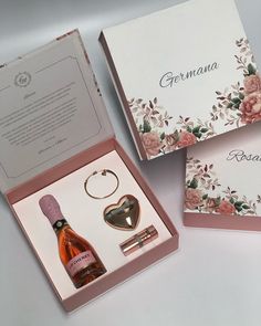 a bottle of wine and keychain in a pink box with flowers on it