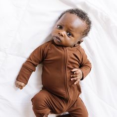 Brave Little Ones loungewear is made from buttery soft bamboo viscose. Our luxurious material keeps your little one comfortable and stylish, day and night. Every purchase helps provide over 550 meals a month to children in Rwanda, Africa. Product Highlights: 95% Viscose From Bamboo/ 5% Spandex Fold Over Mittens up to Size 6-12M Two-Way Double Zipper Fold-Over Feet Our bamboo viscose fabric is Oeko-Tex® Standard 100 certified and has been rigorously tested against hundreds of toxic chemicals. Ribbed Cotton Onesie For Loungewear, Solid Long Sleeve Onesie For Bedtime, Solid Long Sleeve Bedtime Onesie, Brown Long Sleeve Sleepwear, Rwanda Africa, Womens Matching Sets, Swaddle Sets, Toddler Blanket, Toxic Chemicals